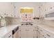 Bright kitchen features white cabinets, stainless steel sink, and modern appliances at 303 Spring St, Louisburg, NC 27549