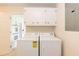 Functional laundry area featuring modern appliances, upper cabinets, and access to kitchen at 303 Spring St, Louisburg, NC 27549