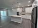 Open kitchen with white cabinets, stainless steel appliances, island and sleek grey flooring at 3191 Mission Olive Pl # 350, New Hill, NC 27562