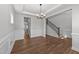 Open-concept foyer with hardwood floors, wainscoting, modern lighting, and a stairway to the second level at 3500 Bailey Lake Dr, Fuquay Varina, NC 27526