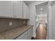 Walk-in pantry boasts granite countertops, cabinets, tile backsplash, and hardwood floors at 3500 Bailey Lake Dr, Fuquay Varina, NC 27526