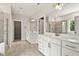 Bathroom with double sinks, quartz countertops, and a tiled shower with a glass door at 359 Abbot Pl, Chapel Hill, NC 27516
