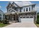 Charming two-story home showcasing a stone and siding exterior, lush landscaping, and a welcoming two-car garage at 359 Abbot Pl, Chapel Hill, NC 27516