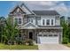 Charming two-story home showcasing a stone and siding exterior, lush landscaping, and a welcoming two-car garage at 359 Abbot Pl, Chapel Hill, NC 27516