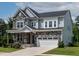 Beautiful home featuring a stone facade, covered front porch, two-car garage, and manicured lawn at 359 Abbot Pl, Chapel Hill, NC 27516