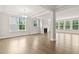 Open-concept living room with hardwood floors, a fireplace, and natural light from large windows at 359 Abbot Pl, Chapel Hill, NC 27516