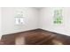 Bright bedroom featuring hardwood floors, two windows, and neutral walls at 407A Edward St, Durham, NC 27701
