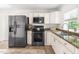Well-lit kitchen featuring stainless steel appliances, granite countertops, and white cabinets at 407A Edward St, Durham, NC 27701