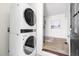 Modern laundry area with stacked washer and dryer and a view to hallway at 407A Edward St, Durham, NC 27701