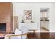 Bright living room with a brick fireplace, hardwood floors, and modern furnishings at 407A Edward St, Durham, NC 27701