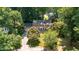 Aerial view of a brick home surrounded by mature trees in a lush, green neighborhood at 4200 Marvin Pl, Raleigh, NC 27609