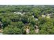 An aerial view shows the house nestled among mature trees in a quiet neighborhood with city views in the distance at 4200 Marvin Pl, Raleigh, NC 27609