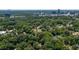 An aerial view shows the house nestled among mature trees in a quiet neighborhood with city views in the distance at 4200 Marvin Pl, Raleigh, NC 27609