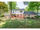 Spacious backyard with mature trees, a wooden deck, and a charming brick house at 4200 Marvin Pl, Raleigh, NC 27609