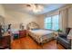 Well-lit bedroom with hardwood floors, a ceiling fan, and a comfortable chair at 4200 Marvin Pl, Raleigh, NC 27609