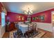 Formal dining room featuring red walls, elegant lighting, and hardwood floors at 4200 Marvin Pl, Raleigh, NC 27609