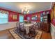 Formal dining room featuring red walls, elegant lighting, and hardwood floors at 4200 Marvin Pl, Raleigh, NC 27609