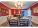 Formal dining room featuring red walls, elegant lighting, and hardwood floors at 4200 Marvin Pl, Raleigh, NC 27609