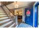 Inviting foyer with staircase, stone flooring, and a view into the living area at 4200 Marvin Pl, Raleigh, NC 27609
