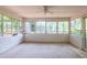 Bright sunroom with white brick walls, carpeted floor, and multiple windows offering ample natural light at 4200 Marvin Pl, Raleigh, NC 27609