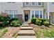 Townhome with a welcoming entrance, concrete steps and lush landscaping surrounding the front at 4353 Sugarbend Way, Raleigh, NC 27606