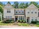 Two-story townhome with neutral siding, black front door, and well-maintained landscaping with mature flowering bushes at 4353 Sugarbend Way, Raleigh, NC 27606