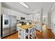 Bright kitchen features stainless steel appliances, island with seating, and white cabinets at 4353 Sugarbend Way, Raleigh, NC 27606