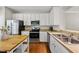Well-lit kitchen features stainless steel appliances, white cabinets, and an island with a butcher block countertop at 4353 Sugarbend Way, Raleigh, NC 27606