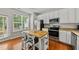Bright kitchen features white cabinets, stainless steel appliances, and a central island with seating at 4353 Sugarbend Way, Raleigh, NC 27606