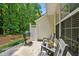 Charming outdoor patio featuring a grill, string lights, and comfortable seating with wooded views at 4353 Sugarbend Way, Raleigh, NC 27606