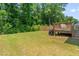 Spacious backyard with a wooden fence, green grass, and a deck at 445 Sturgeon St, Smithfield, NC 27577