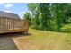 Backyard features a wooden fence, green grass, and view of the deck at 445 Sturgeon St, Smithfield, NC 27577