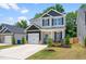 Charming two-story home featuring a bright blue door, attached garage, and a well-manicured lawn with flower beds at 445 Sturgeon St, Smithfield, NC 27577