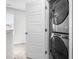 Laundry closet with stacked washer and dryer units, and a view to a bright, window-lit hallway at 445 Sturgeon St, Smithfield, NC 27577