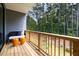 View of a cozy balcony with wooded view, stylish seating, and modern orange accent stools at 4713 Mint Leaf Ln, Raleigh, NC 27612