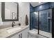 Modern bathroom featuring blue tiled shower with glass door, undermount sink, and sleek fixtures at 4713 Mint Leaf Ln, Raleigh, NC 27612