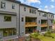 Exterior of grey townhomes with private balconies, a well-manicured lawn, and patio seating at 4713 Mint Leaf Ln, Raleigh, NC 27612