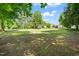 Expansive backyard with mature trees and grass, and two homes in the background at 4720 Cedarfield Dr, Raleigh, NC 27606