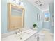 Bathroom with a large gold-framed mirror, marble countertops, and soft blue walls at 4720 Cedarfield Dr, Raleigh, NC 27606