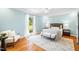 Serene bedroom with hardwood floors, a ceiling fan, and a large window offering views of the green lawn at 4720 Cedarfield Dr, Raleigh, NC 27606