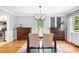 Bright dining room featuring hardwood floors, a stylish chandelier, and views of the backyard at 4720 Cedarfield Dr, Raleigh, NC 27606