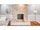 Inviting living room with a stone fireplace and hardwood flooring, offering a cozy focal point and a warm ambiance at 4720 Cedarfield Dr, Raleigh, NC 27606