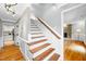 Elegant staircase with wood treads and white risers, leading to the upper level at 4720 Cedarfield Dr, Raleigh, NC 27606