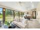 Sunroom with a stone wall and a compass, an off-white sofa, and large windows with a view at 4720 Cedarfield Dr, Raleigh, NC 27606