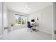 A sunlit bedroom offers a versatile space with a ceiling fan and a large window view at 4805 Castle Crest Ct, Raleigh, NC 27616