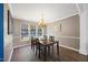 Dining room featuring a wooden table, chandelier, and ample natural light from large windows at 4805 Castle Crest Ct, Raleigh, NC 27616