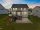 Rear exterior of home featuring a fenced-in yard, deck, patio, and play set, perfect for outdoor enjoyment at 525 Marion Hills Way, Knightdale, NC 27545