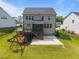 Backyard view showcasing a wooden playset, covered deck with stairs, and concrete patio at 525 Marion Hills Way, Knightdale, NC 27545