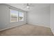 A bright bedroom with neutral walls, carpet flooring, ceiling fan and large window at 525 Marion Hills Way, Knightdale, NC 27545