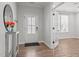 Bright entryway featuring hardwood floors, a stylish console table with flowers, and a glass-paneled front door at 525 Marion Hills Way, Knightdale, NC 27545